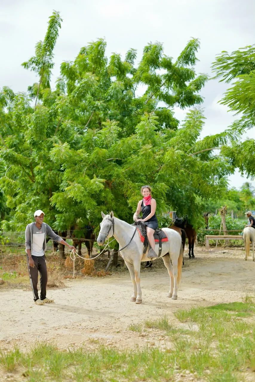 Participante sobre un caballo blanco junto a un acompañante, foto aportada por Go Buggies Punta Cana.